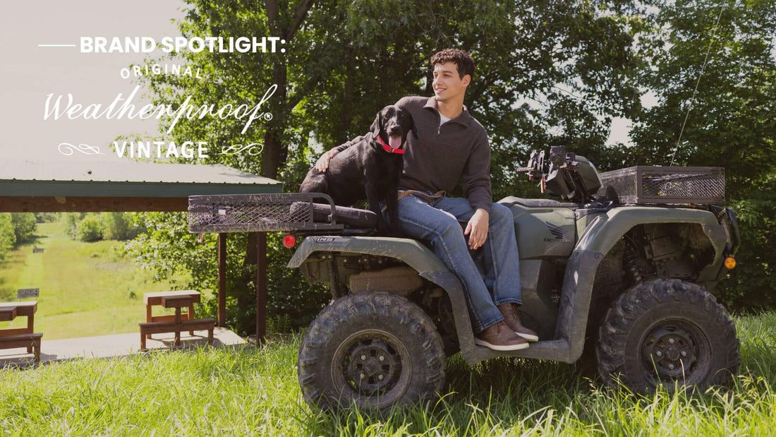 A man sits on a vintage all-terrain vehicle outdoors with a black dog beside him, with trees, grass, and a covered picnic area in the background. Text on the left reads 'BRAND SPOTLIGHT: Original Weatherproof Vintage.