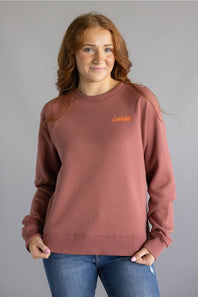 Dark red colored sweatshirt with orange Carhartt cursive letters on chest 