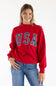 A woman wearing a red crewneck sweatshirt with 'USA' printed across the chest in white block letters filled with small white stars on a navy blue background, paired with blue jeans, against a plain white studio background.