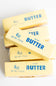 Four sticks of 4oz salted butter squishy toys on a white background