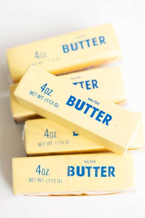 Four sticks of 4oz salted butter squishy toys on a white background