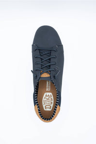 A dark navy blue sneaker viewed from above with a leather HEYDUDE logo patch on the shoe tongue and white HEYDUDE logo on heel bed and navy and white stripes on shoe inner displayed on a clean white studio background.