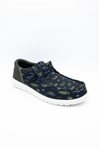 A single casual slip-on shoe with a navy blue canvas upper covered in a colorful alligator print, featuring a dark gray heel tab, matching laces, and a white sole, shown on a white background.