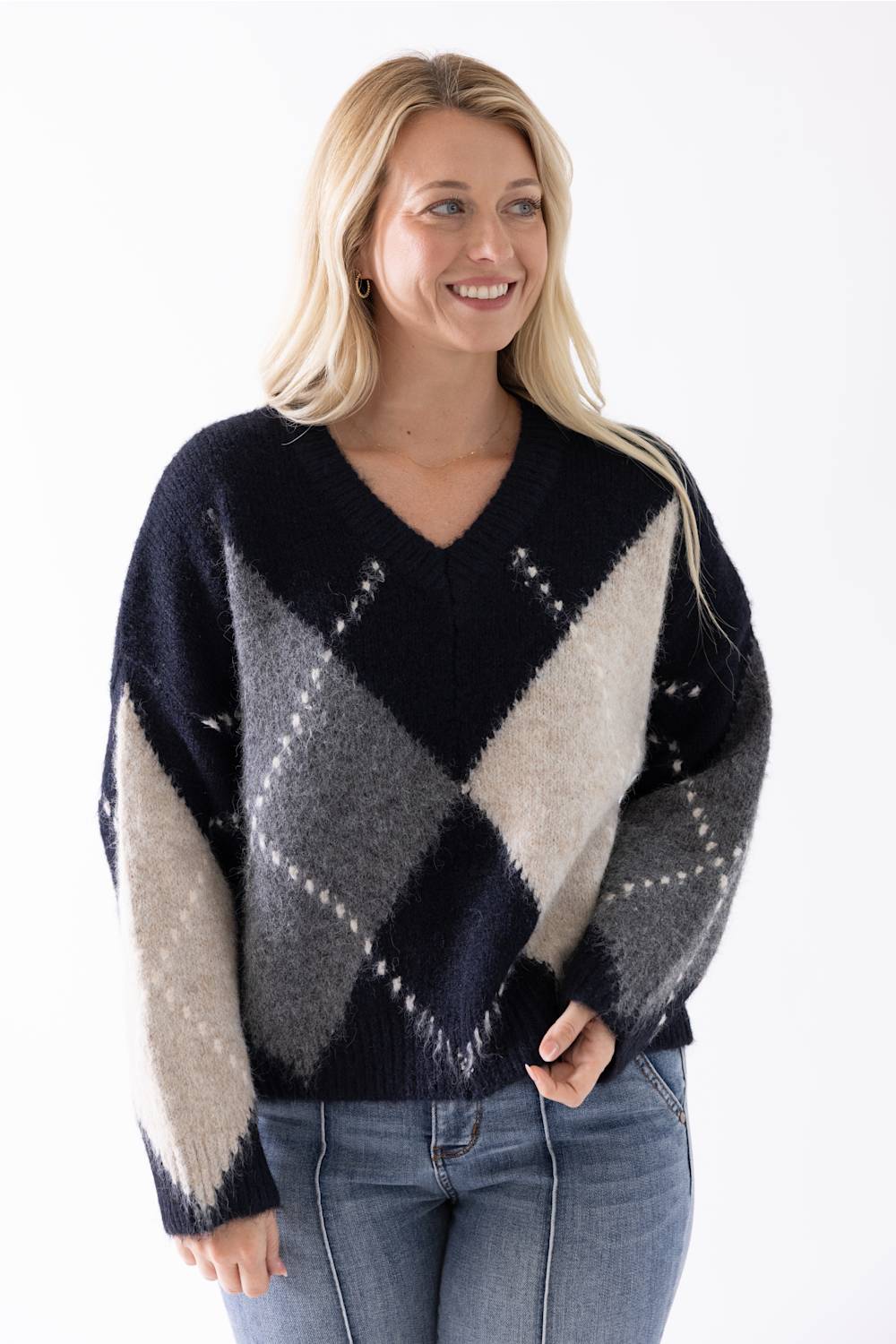 Blonde woman modeling a stylish argyle sweater 