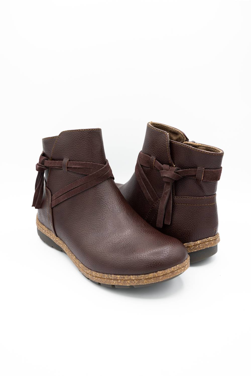 A pair of dark brown faux-leather ankle boots with side bow details and a cork-look sole, shown on a white background.