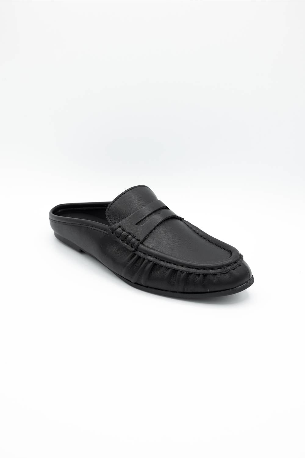 A single black leather loafer-style mule shoe with a decorative strap across the vamp, photographed on a clean white studio background.