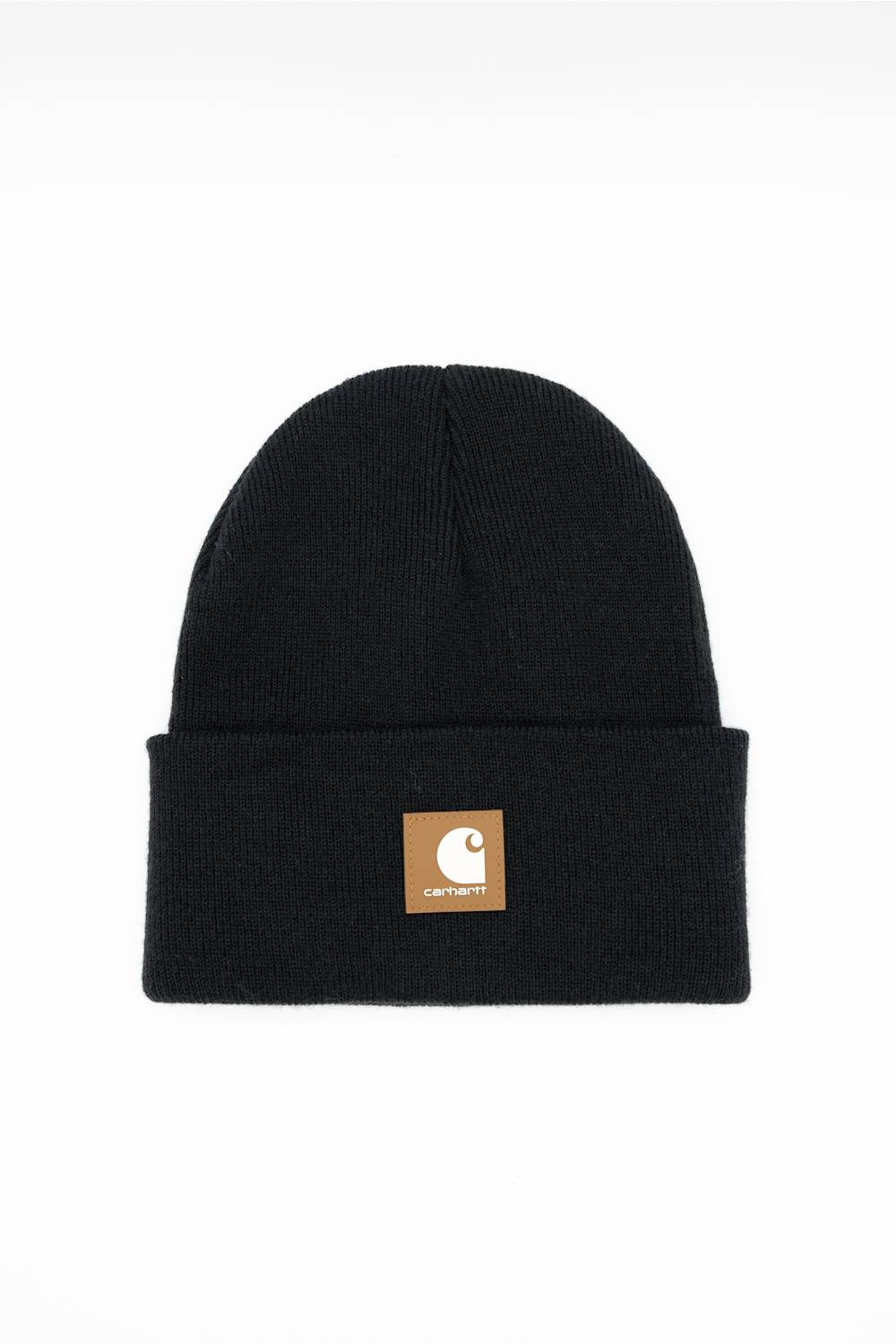 A black ribbed knit beanie hat with a folded cuff, featuring a small tan square patch on the front with the Carhartt logo, set against a plain white background.