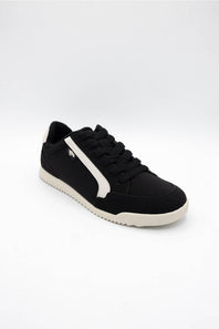 A black low-top sneaker with a white side stripe, black laces, and a white sole, photographed on a seamless white background.