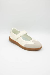 A single Mary Jane shoe in off-white and light beige suede, featuring a brown gum sole, photographed on a light gray studio background.