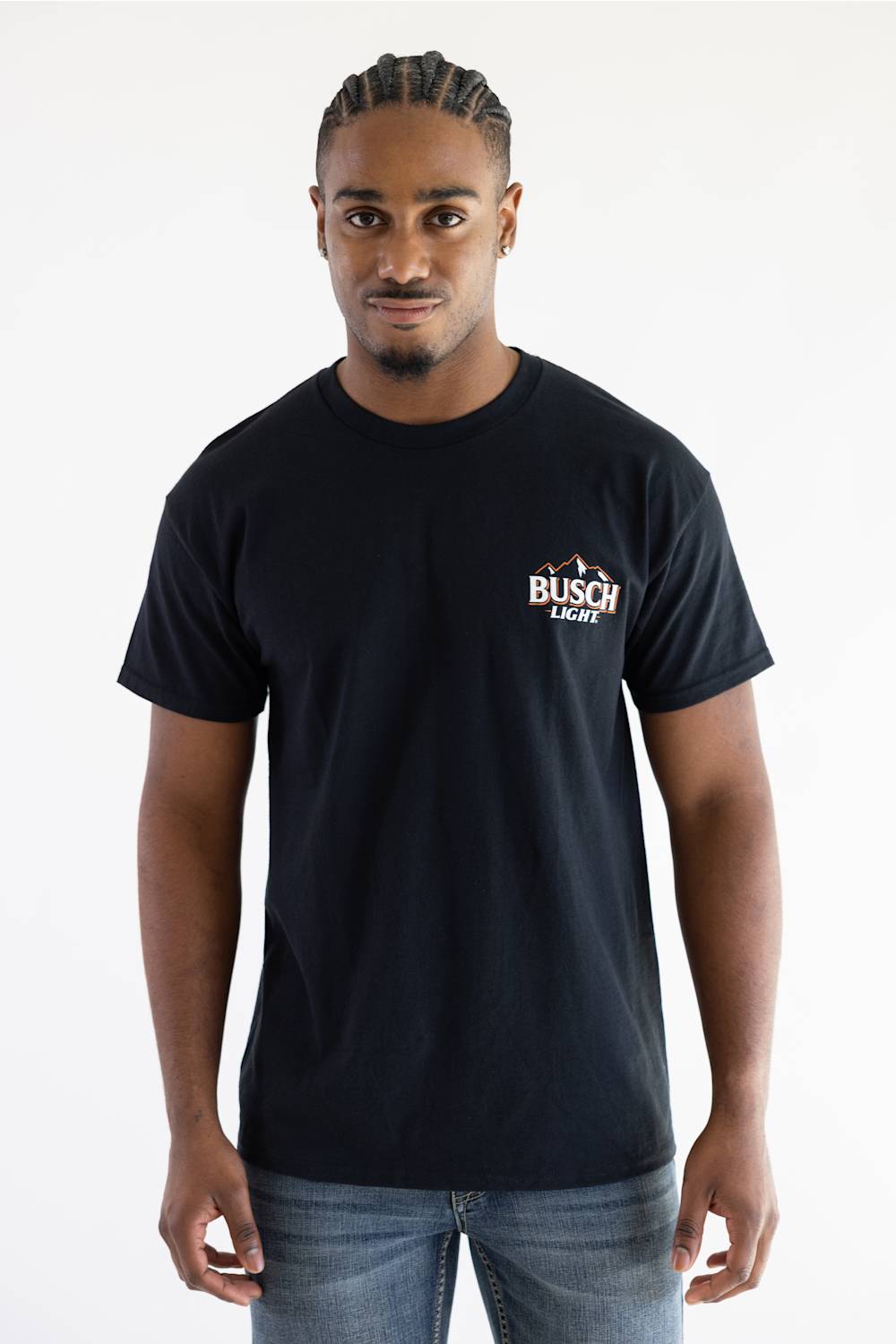 A front-view photograph of a male model with braided hair wearing the black Busch Light Can Evolution T-Shirt. The shirt features a small Busch Light logo graphic on the left chest.