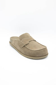 A single taupe suede slip-on clog shoe with a decorative strap across the vamp, shown from a three-quarters angle on a white background.