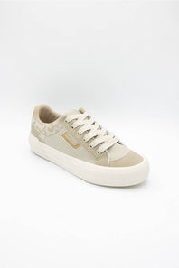 A low-top canvas sneaker in beige and off-white, featuring a patterned heel panel, white laces, and a thick white rubber sole, shown on a light gray background.