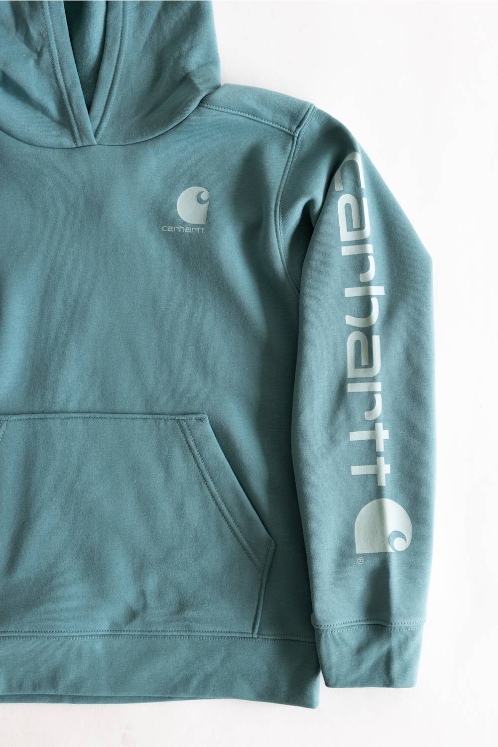 A teal blue-green Carhartt pullover hoodie with a front kangaroo pocket, featuring a small Carhartt logo on the left chest and a large vertical Carhartt logo printed in white on the right sleeve.