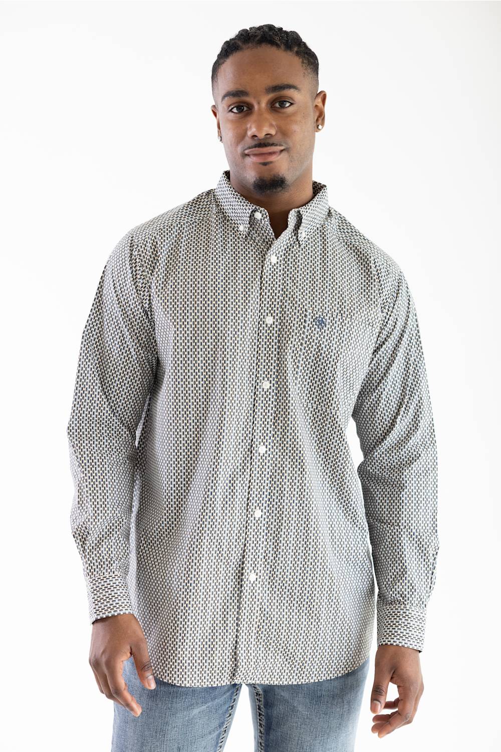 A man wearing a long-sleeve button-down shirt with a small white geometric pattern on a light gray background, paired with blue jeans, photographed against a plain white studio background.