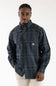 Front view of a male model wearing the Carhartt Fort Loose Plaid Shirt in navy and green plaid with two chest pockets against a white background.