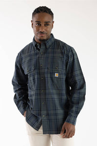 Front view of a male model wearing the Carhartt Fort Loose Plaid Shirt in navy and green plaid with two chest pockets against a white background.