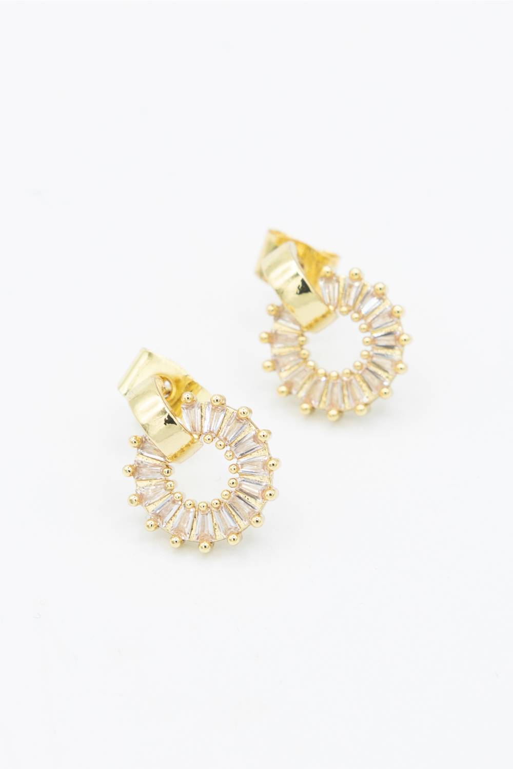 A pair of gold hoop earrings with clear baguette crystals arranged in a sunburst pattern, shown on a plain white background.