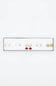 A white rectangular jewelry display tray holding multiple pairs of earrings on a plain white background. The earrings include gold and silver-toned pieces with clear stones and one pair with red stones.