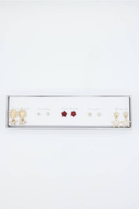 A white jewelry display tray holding multiple pairs of stud earrings on small cards, photographed against a plain white background.