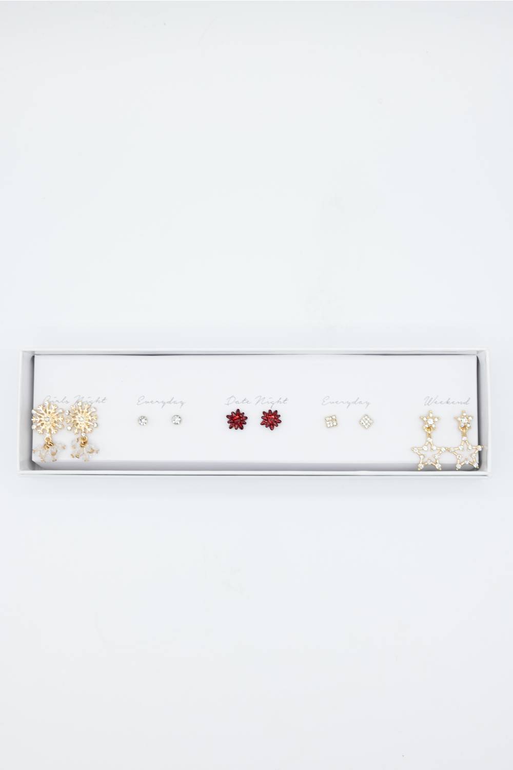 A white jewelry display tray holding multiple pairs of stud earrings on small cards, photographed against a plain white background.