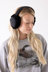 A woman with long blonde hair wearing charcoal grey C.C. heather knit earmuffs with black faux fur and a grey sweatshirt.