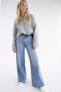 Model posing with a wide leg jean, cropped grey sweater