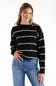 Model styled in a black crew neck knit sweater featuring textured tan and white horizontal stripes, ribbed hem and cuffs, paired with classic blue denim jeans against a white background.