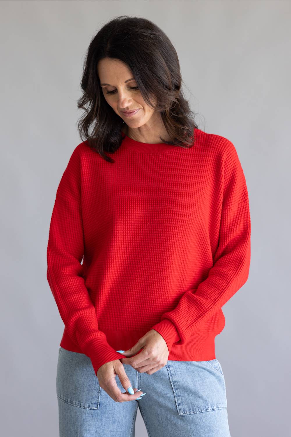 Waffle textured sweater top in a vibrant red color, with thick hems and cuffs 
