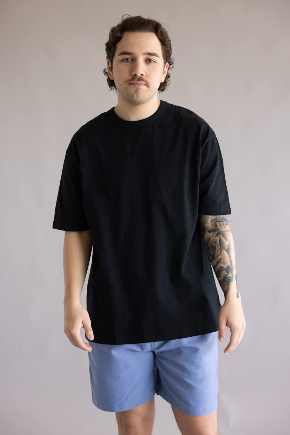 Industrie Del Sur T-Shirt for Men in Black; Man wearing a black t-shirt and blue shorts against a plain background