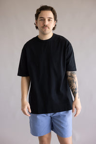 Industrie Del Sur T-Shirt for Men in Black; Man wearing a black t-shirt and blue shorts against a plain background