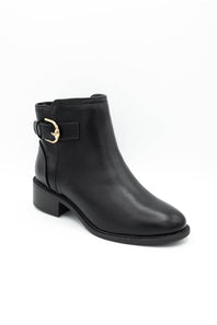 A black leather ankle boot with a low block heel and a gold buckle detail on the side, shown against a plain white background.