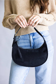 Crescent shaped faux suede shoulder bag with an adjustable buckle detail on strap