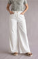 Judy Blue White Featherweight Palazzo Jeans for Women in White; Person wearing a green patterned top and white wide-leg pants on a plain background