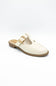 An off-white faux leather mule shoe with a T-strap featuring a gold-tone buckle, set against a plain white background.