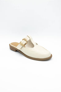 An off-white faux leather mule shoe with a T-strap featuring a gold-tone buckle, set against a plain white background.