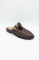 A dark brown leather mule sandal with a decorative gold-tone buckle detail on the strap, shown against a plain light gray background.