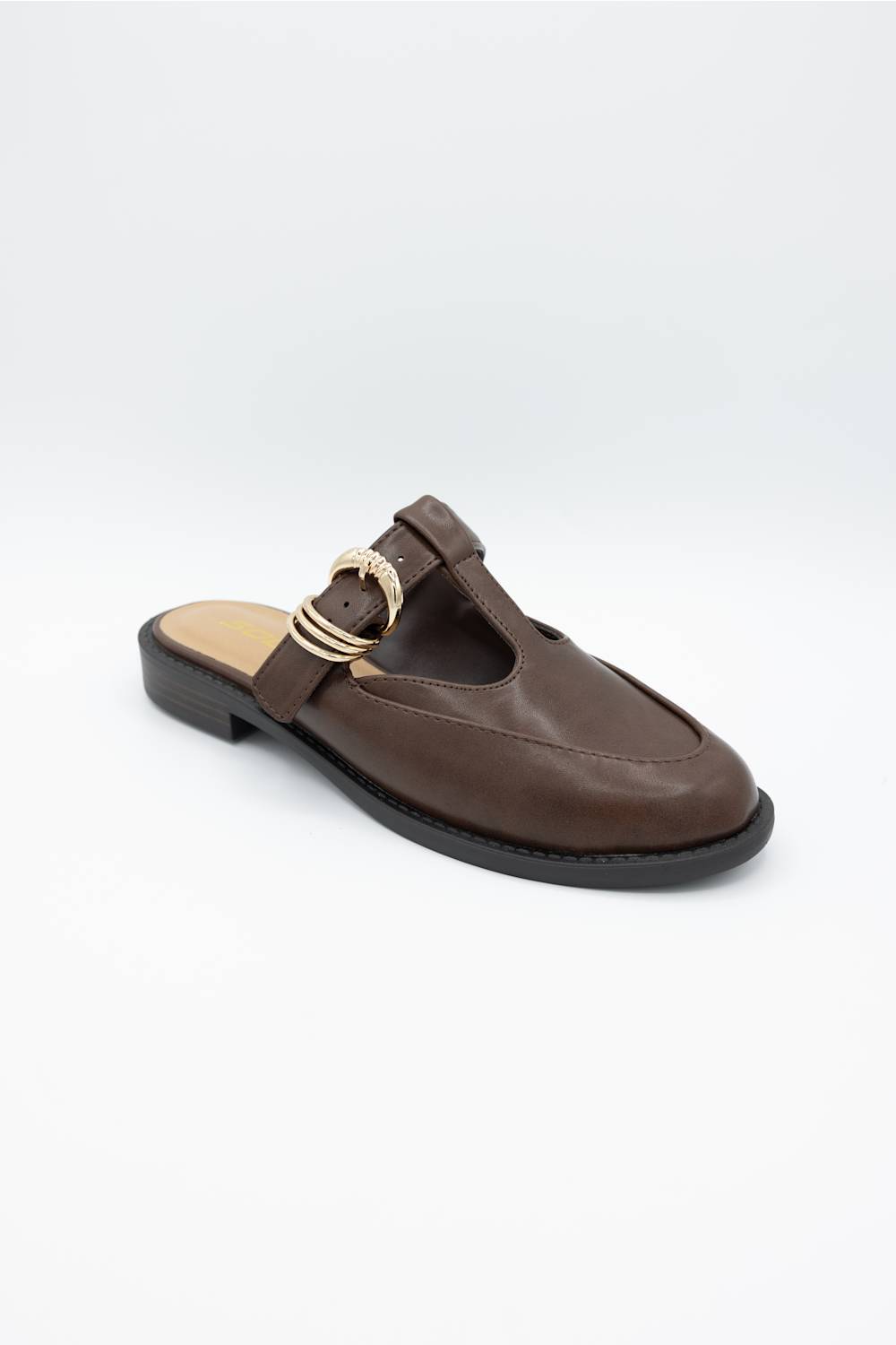 A dark brown leather mule sandal with a decorative gold-tone buckle detail on the strap, shown against a plain light gray background.
