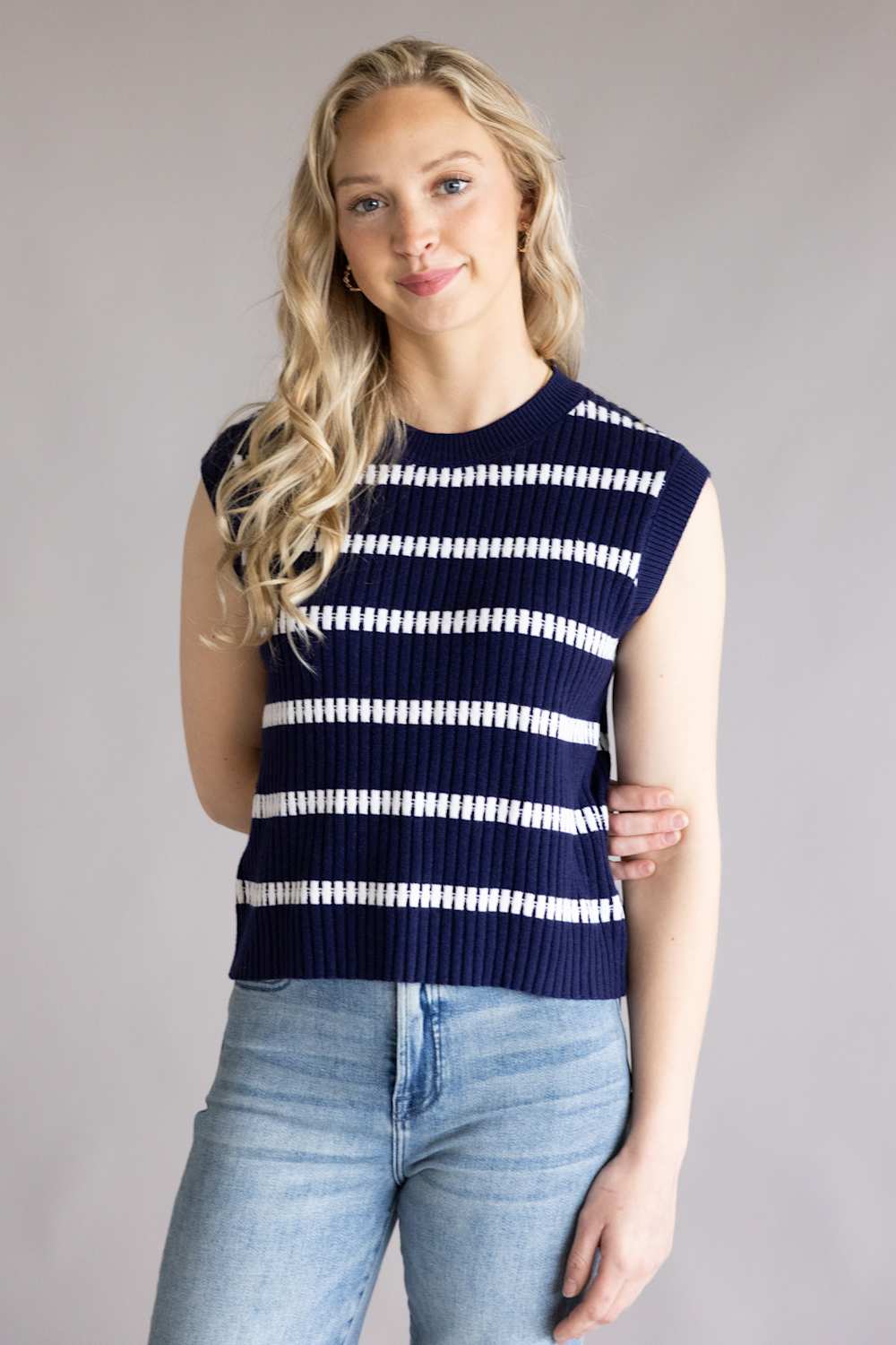 Woman wearing the La Miel Crochet Stripe Top for Women in Galaxy which is a navy blue and white striped sleeveless sweater against a plain background
