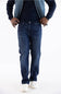 Axel Jeans Men's Landon Bondi Wash Bootcut Jeans worn with a dark shirt, blue jacket, and white sneakers
