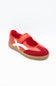 A red  shoe with a white diagonal stripe and a tan sole, photographed on a clean white background.