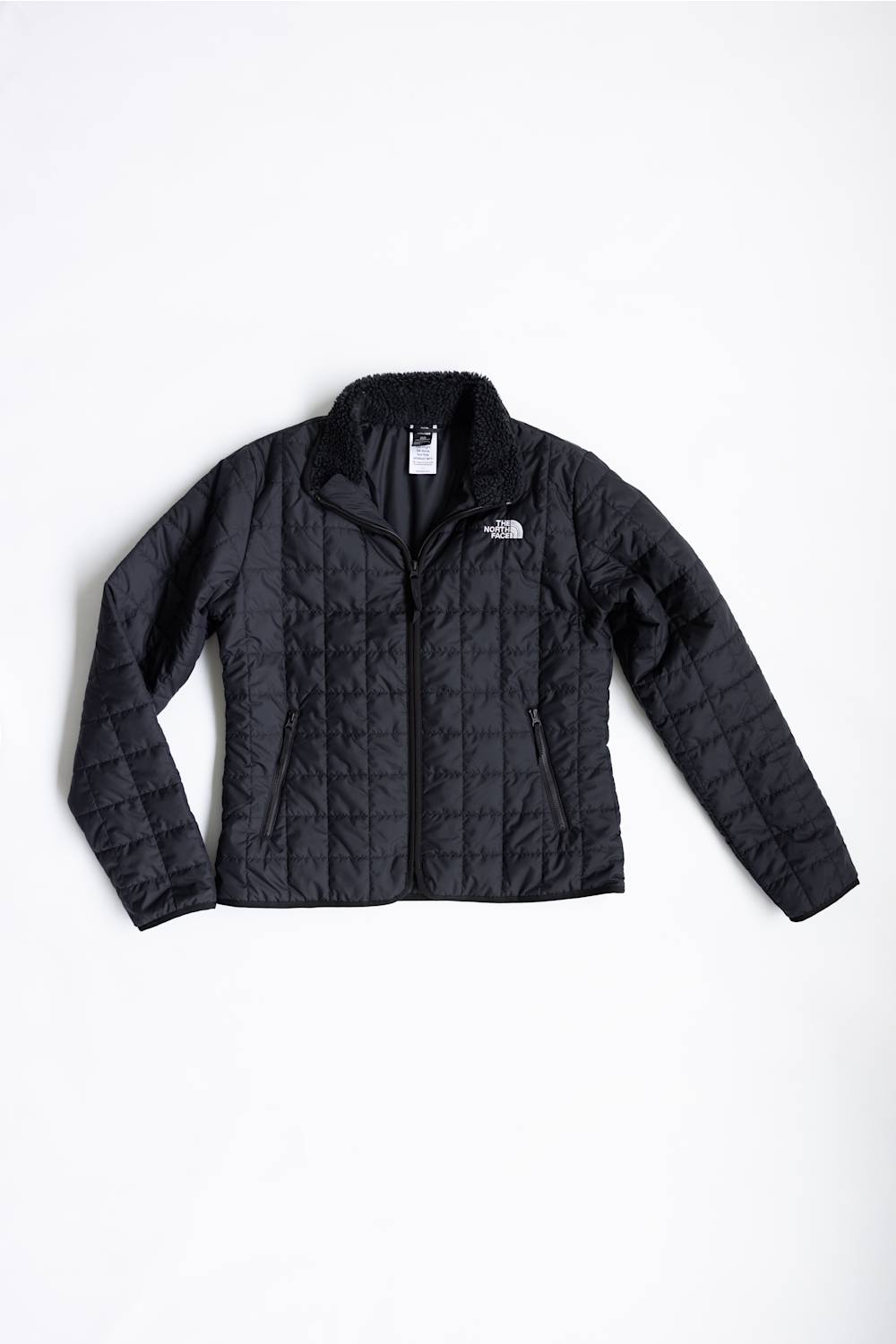 A black quilted puffer jacket by The North Face, laid flat against a clean white background.