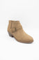 A tan suede ankle boot with a low block heel and a decorative strap across the instep with a metal buckle, shown on a plain white background.