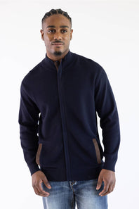 Man wearing a navy mock neck jacket standing against a white background