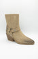 A single beige suede ankle boot with a pointed toe, stacked block heel, and a decorative strap detail with silver-tone studs on the side, shown against a plain white background.