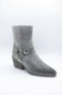 A single gray ankle boot with a textured finish, a stacked block heel, and decorative strap details with silver-tone studs on the side, shown against a plain white background.