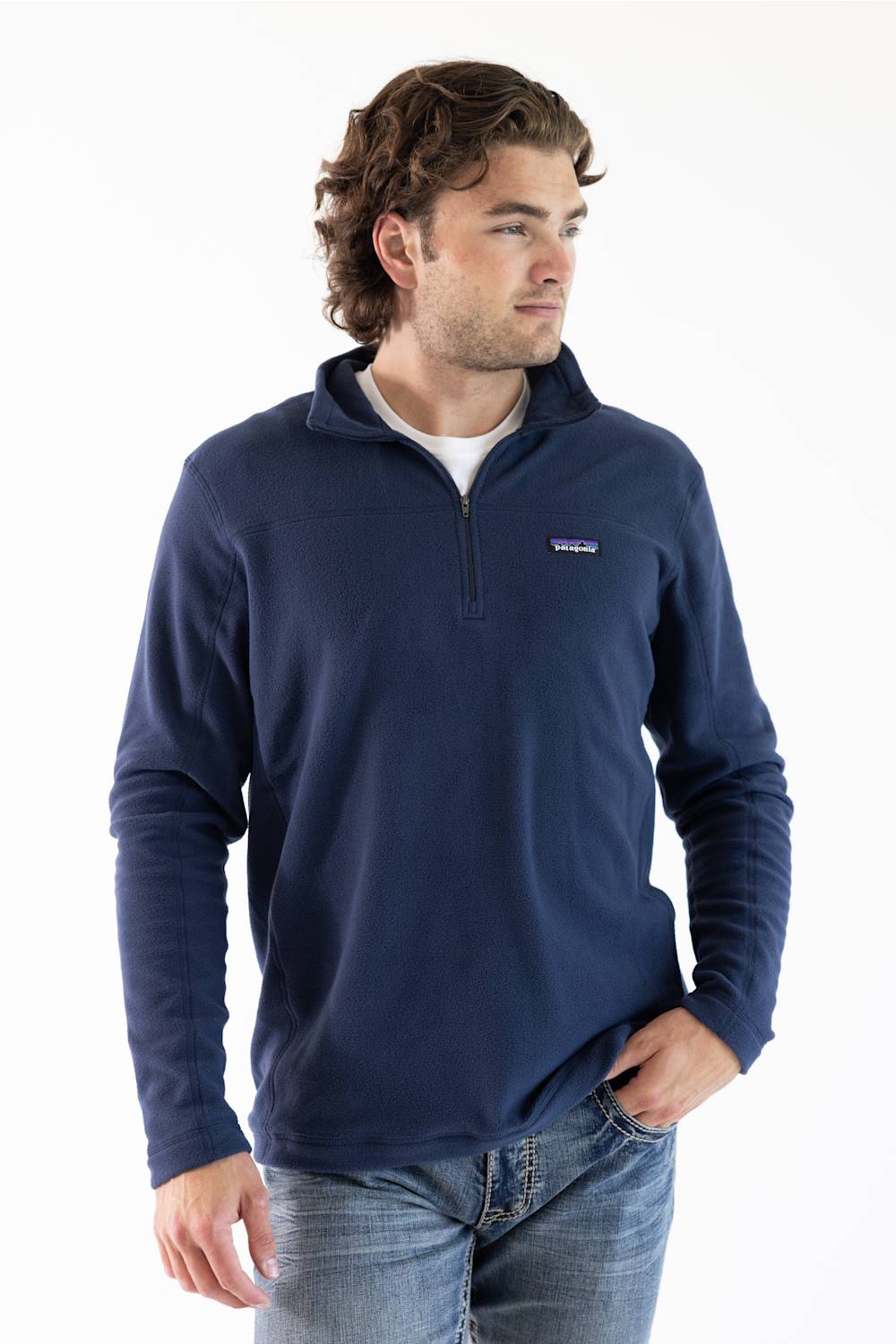 A man wearing a navy blue microfleece quarter zip pullover with a Patagonia logo on the upper left chest.