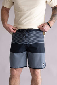 Person wearing black and gray striped shorts on a plain background. The shorts are the Quiksilver SurfSilk Tijuana 19" Boarshorts for Men in Black