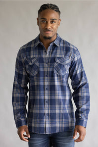Front view of a model wearing the Split Men's long-sleeve flannel shirt in a navy blue, khaki, and white plaid pattern, featuring two button-flap chest pockets, styled with blue jeans against a grey studio background.