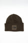 Front view of a dark chestnut brown ribbed knit beanie featuring a folded cuff hem with a square patch displaying The North Face logo against a plain white background.