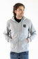 A man wearing a light gray zip-up hoodie with a black chest logo patch, paired with a black t-shirt and blue jeans, photographed against a plain white background.